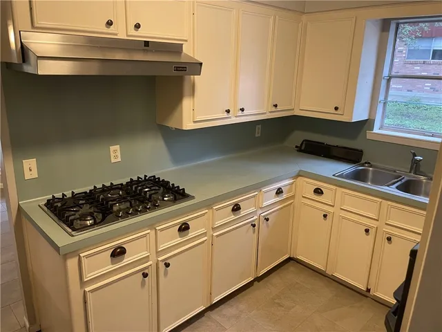 a kitchen with white cabinets and a stove