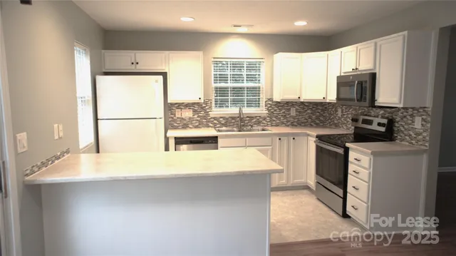 a kitchen with stainless steel appliances a stove a sink and a refrigerator