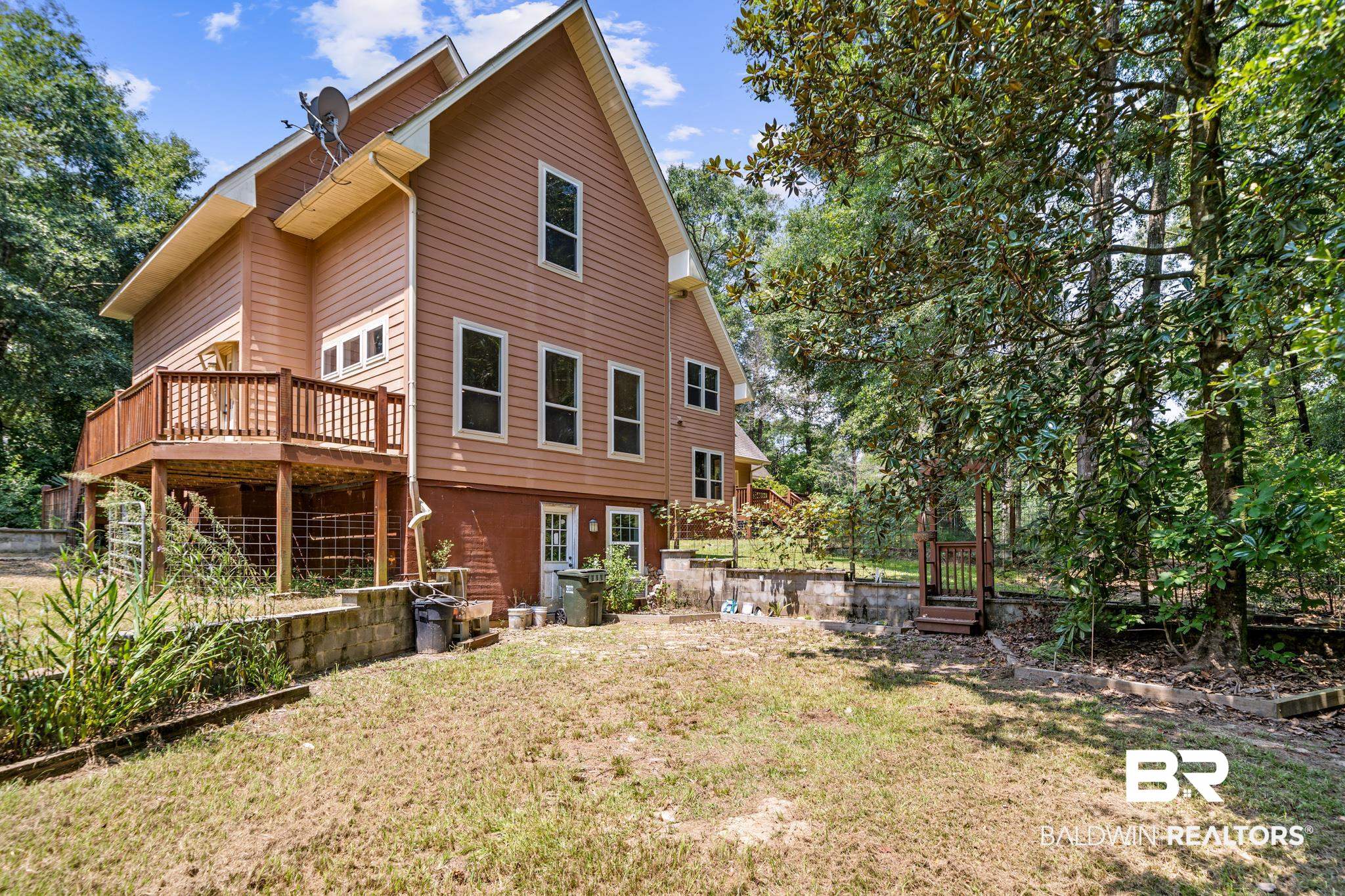 8321 Dixon Road Bay Minette, AL 36507 - Photo 13 of 79 Back of property with a lawn and a wooden deck