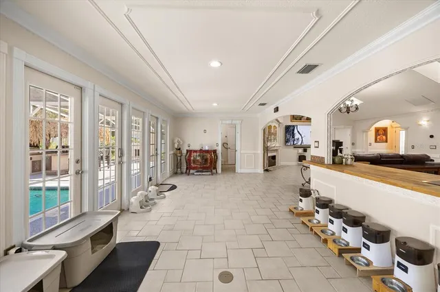 a spacious bedroom with a large bed a chandelier and windows