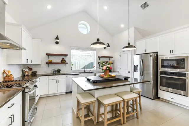 a kitchen with a sink a counter space appliances and cabinets