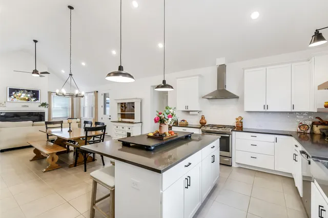 a kitchen with a stove a sink a center island and cabinets