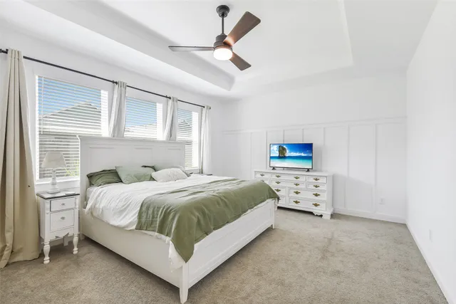 a bedroom with a bed and a ceiling fan