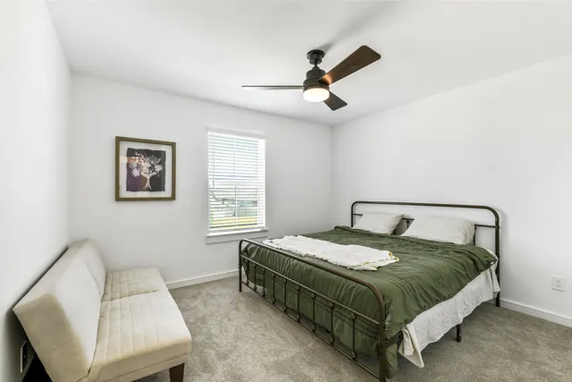 a bed sitting in a bedroom next to a window