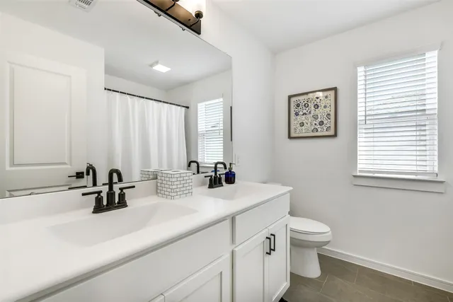 a bathroom with a sink a toilet and mirror