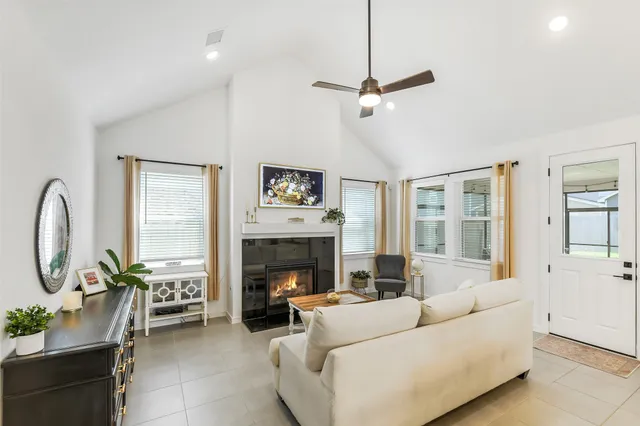 a living room with furniture a large window and a fireplace