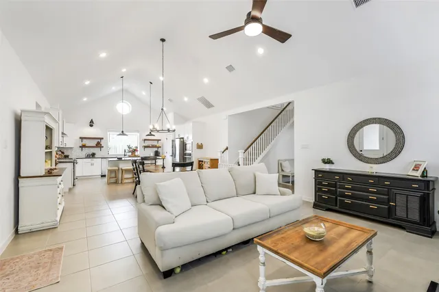 a living room with furniture a fireplace and a chandelier