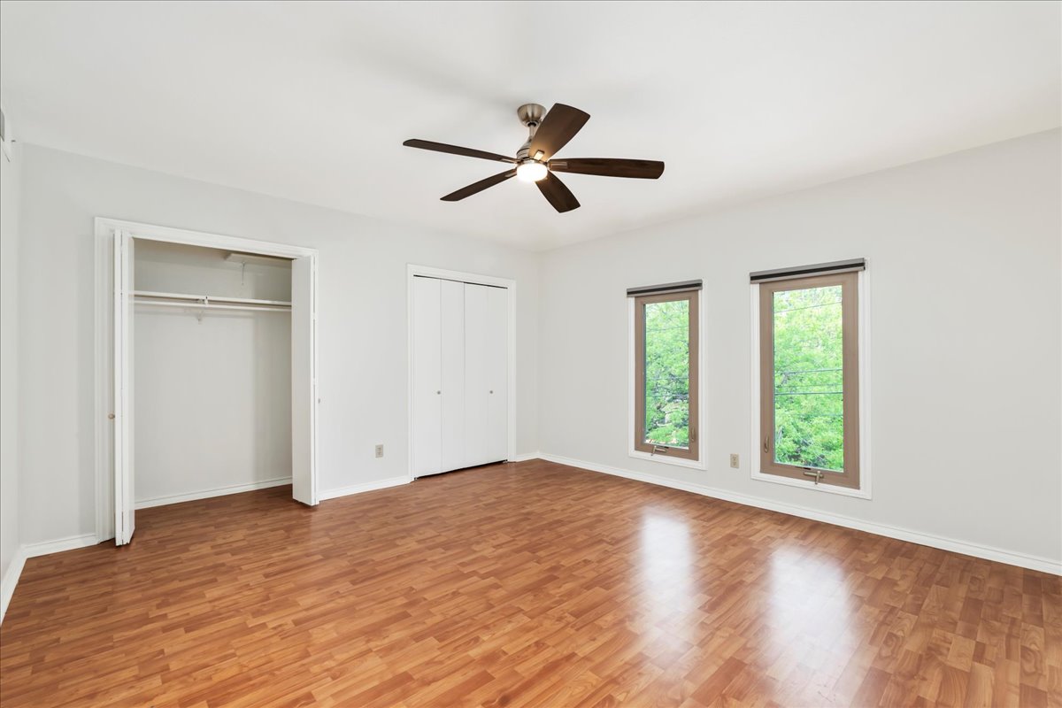 505 West 7th Street, Unit 313 Austin, TX 78701 - Photo 12 of 30 Unfurnished bedroom featuring light wood-style floors, multiple closets, and baseboards