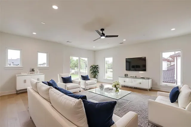 a living room with furniture a flat screen tv and a large window