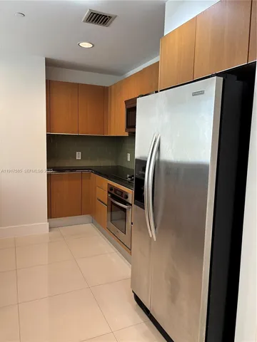 a kitchen with granite countertop a refrigerator and a sink