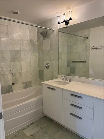 a bathroom with a granite countertop sink a toilet and shower