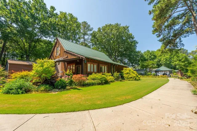 an aerial view of a house with swimming pool and lake view