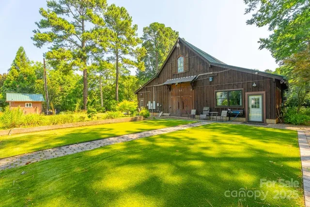 a view of house with swimming pool and a yard