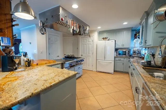 a kitchen with stainless steel appliances granite countertop a stove a sink dishwasher and cabinets with wooden floor