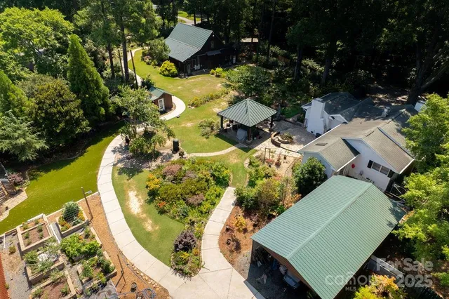 an aerial view of a house with a swimming pool and outdoor seating