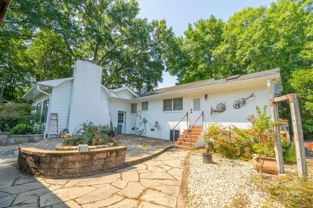 a view of a house with backyard and sitting area