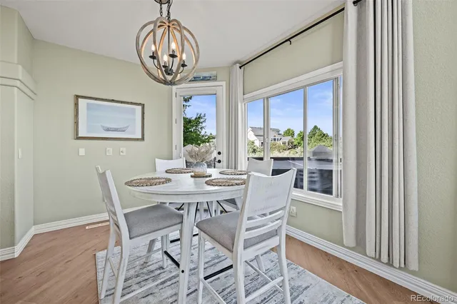 a view of a dining room with furniture a chandelier and wooden floor