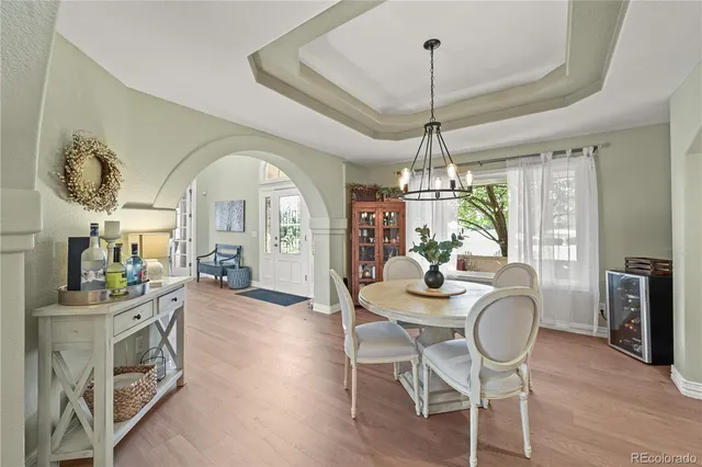a dining room with furniture a chandelier and wooden floor