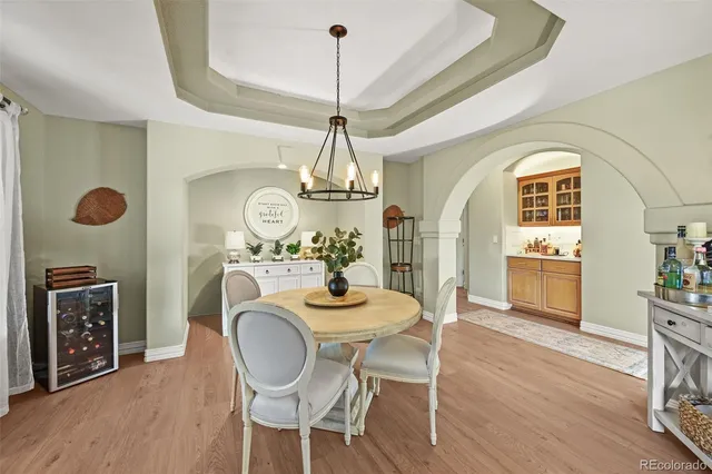 a dining room with furniture a chandelier and wooden floor