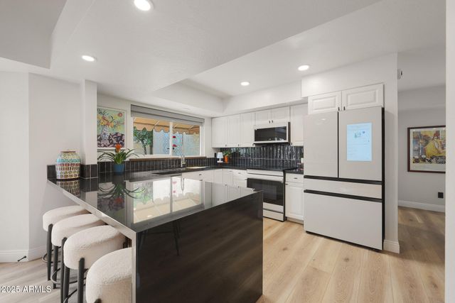 a dining room with furniture a chandelier and kitchen view