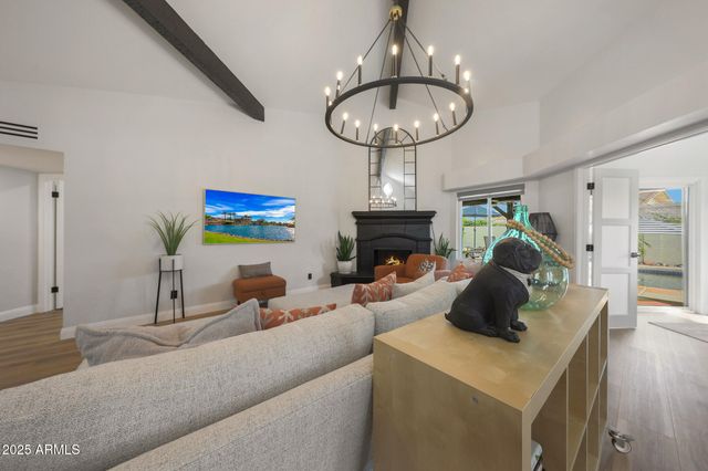a living room with furniture a chandelier and a fireplace