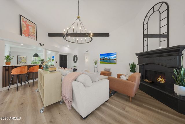 a living room with furniture a chandelier and a fireplace