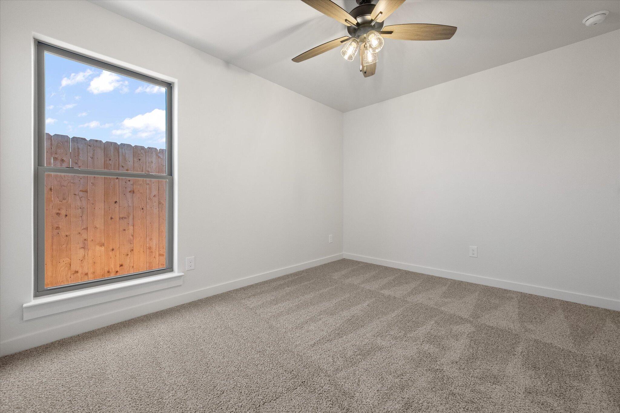 606 East 22nd Street Wolfforth, TX 79382 - Photo 16 of 19 an empty room with windows and fan