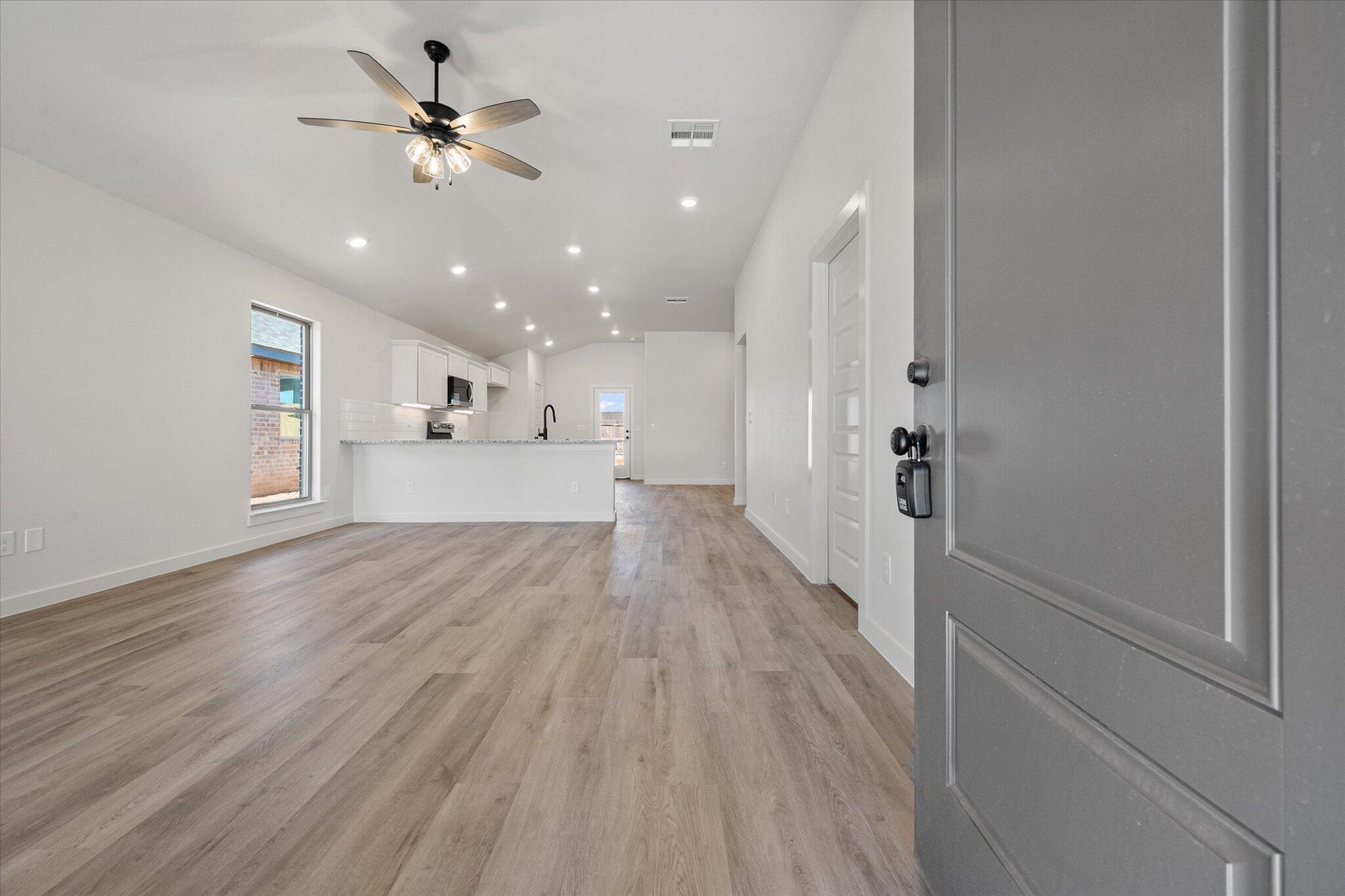 606 East 22nd Street Wolfforth, TX 79382 - Photo 2 of 19 a view of a big room with wooden floor and a ceiling fan