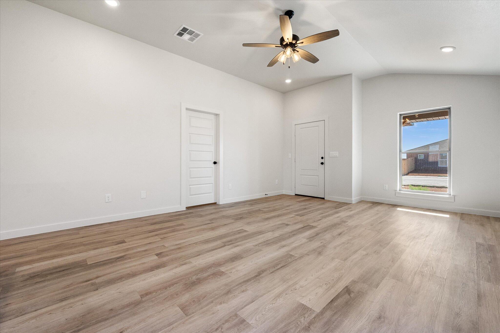606 East 22nd Street Wolfforth, TX 79382 - Photo 5 of 19 a view of an empty room with window and wooden floor