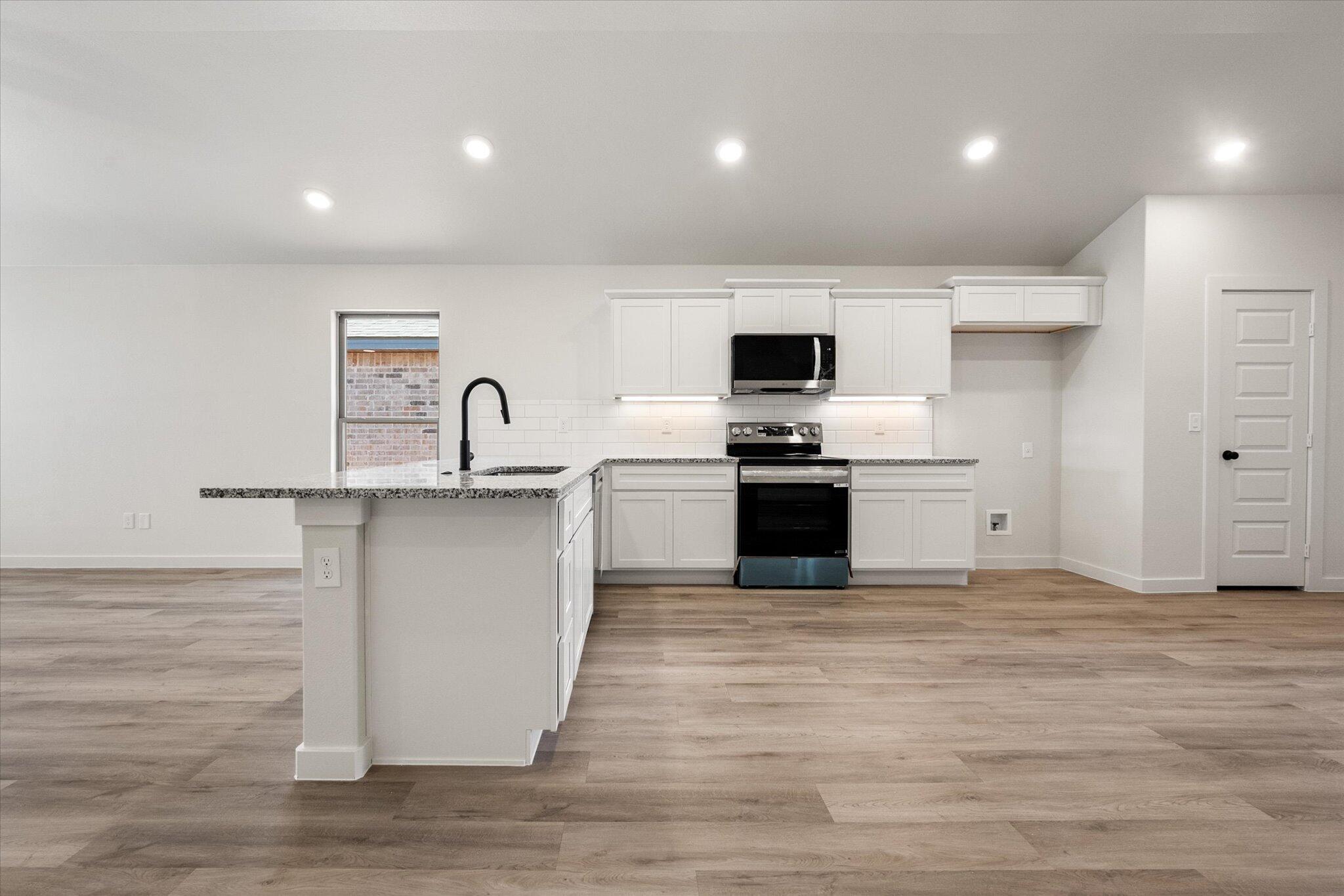 606 East 22nd Street Wolfforth, TX 79382 - Photo 9 of 19 a kitchen with stainless steel appliances granite countertop a sink stove and oven