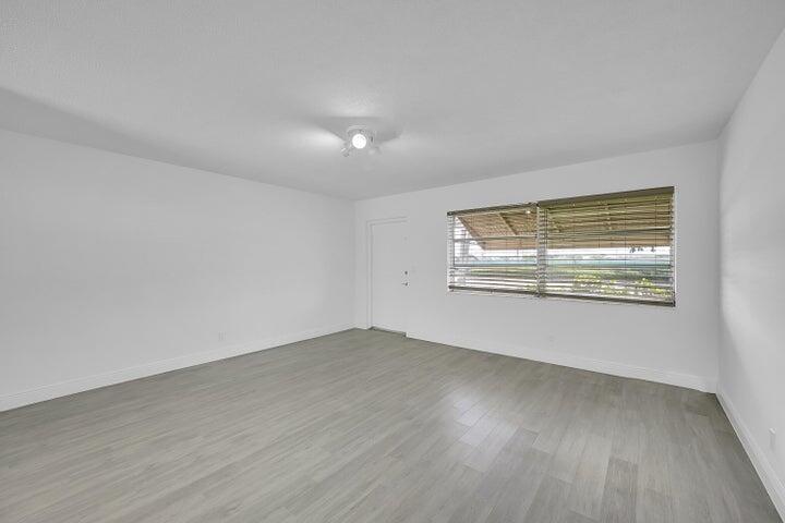 1308 South Congress Avenue Delray Beach, FL 33445 - Photo 20 of 30 a view of an empty room with wooden floor and a window
