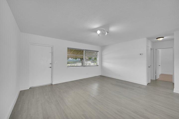 1308 South Congress Avenue Delray Beach, FL 33445 - Photo 21 of 30 an empty room with wooden floor and windows