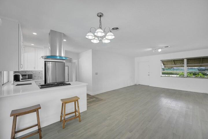 1308 South Congress Avenue Delray Beach, FL 33445 - Photo 28 of 30 a kitchen with stainless steel appliances granite countertop a stove a refrigerator a oven a sink with a dining table and chairs