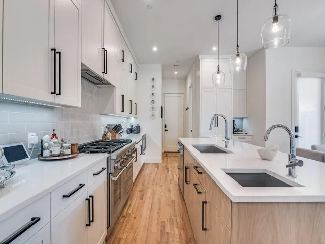 a kitchen with stainless steel appliances a sink stove and cabinets