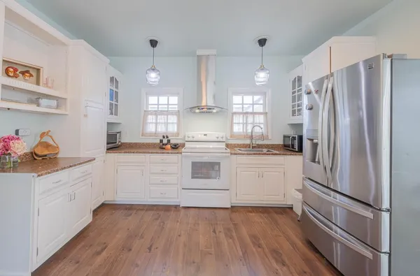 a kitchen with granite countertop white cabinets and stainless steel appliances