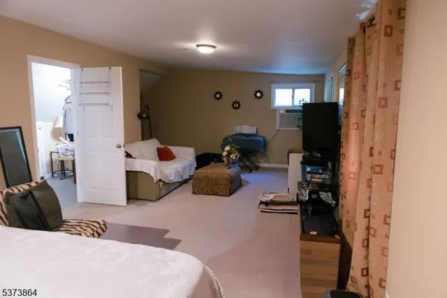 a bedroom with a bed furniture and a flat tv screen