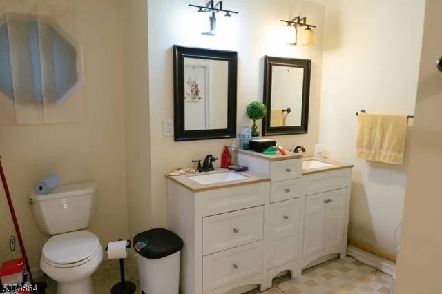 a bathroom with a granite countertop toilet sink and mirror