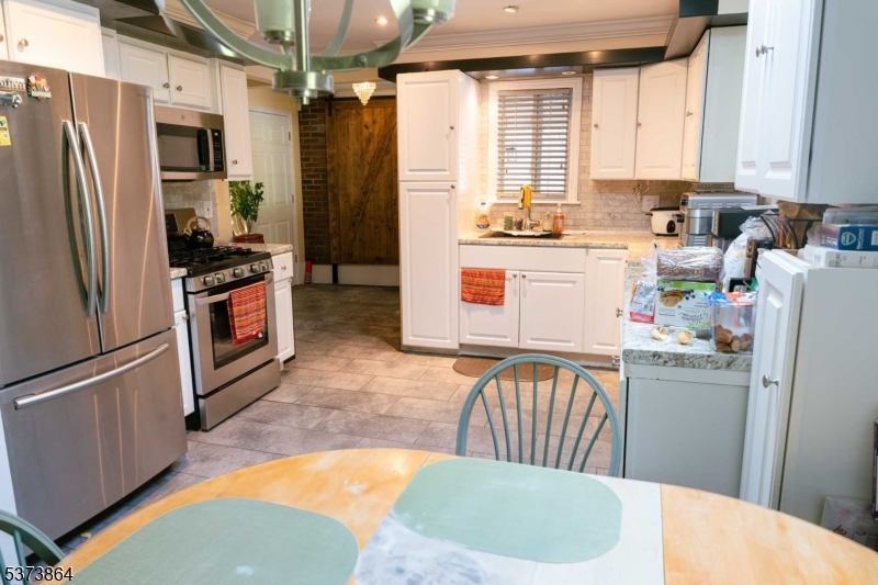 72 East Main Street High Bridge, NJ 08829 - Photo 5 of 35 a kitchen with a refrigerator a stove a sink dishwasher and wooden cabinets with a dining table