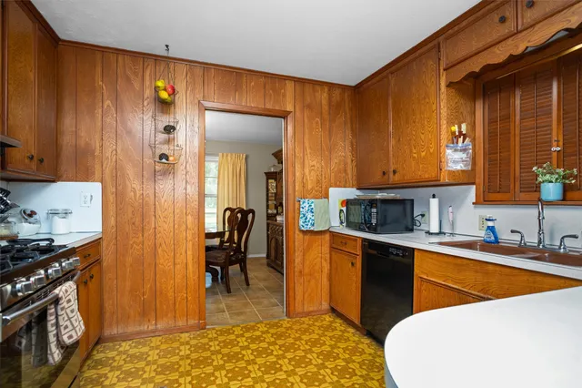 a kitchen with stainless steel appliances granite countertop a sink a stove and a refrigerator