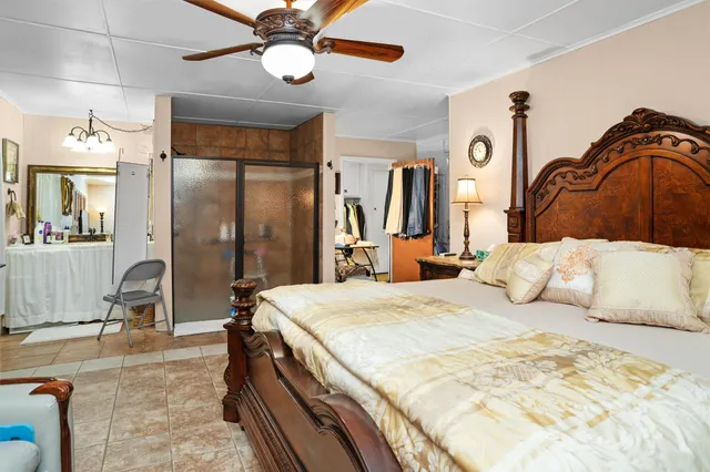 a bedroom with a large bed and a chandelier