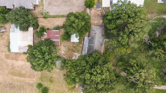 an aerial view of residential house with outdoor space and trees all around