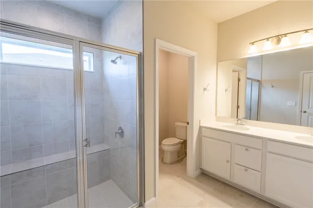 a bathroom with a shower sink vanity and toilet