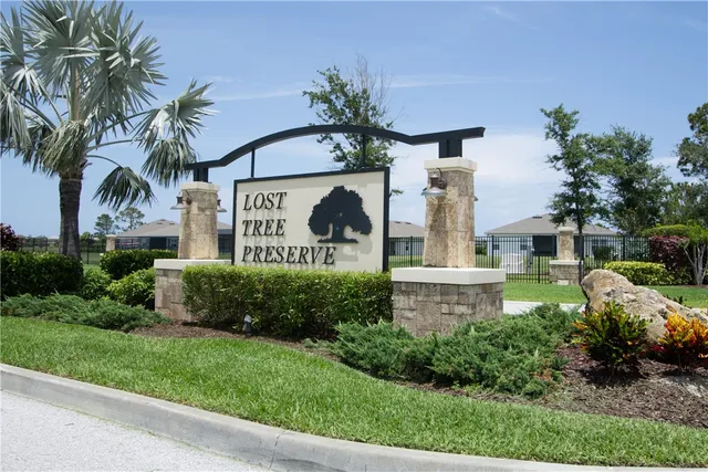 a front view of a house with garden and parking