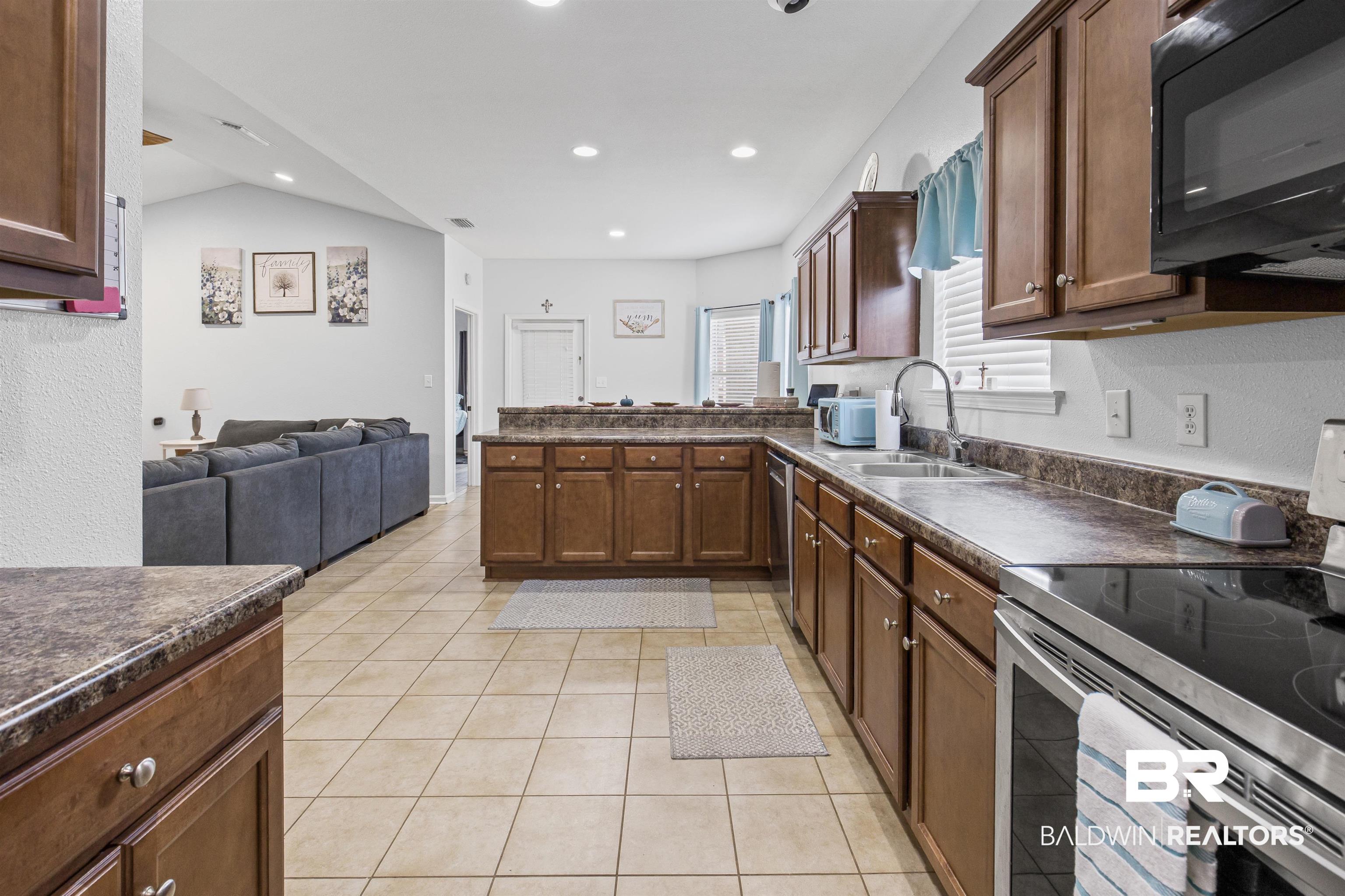 4107 Nottingham Drive Semmes, AL 36575 - Photo 22 of 23 Kitchen with dark countertops, appliances with stainless steel finishes, light tile patterned floors, open floor plan, and recessed lighting