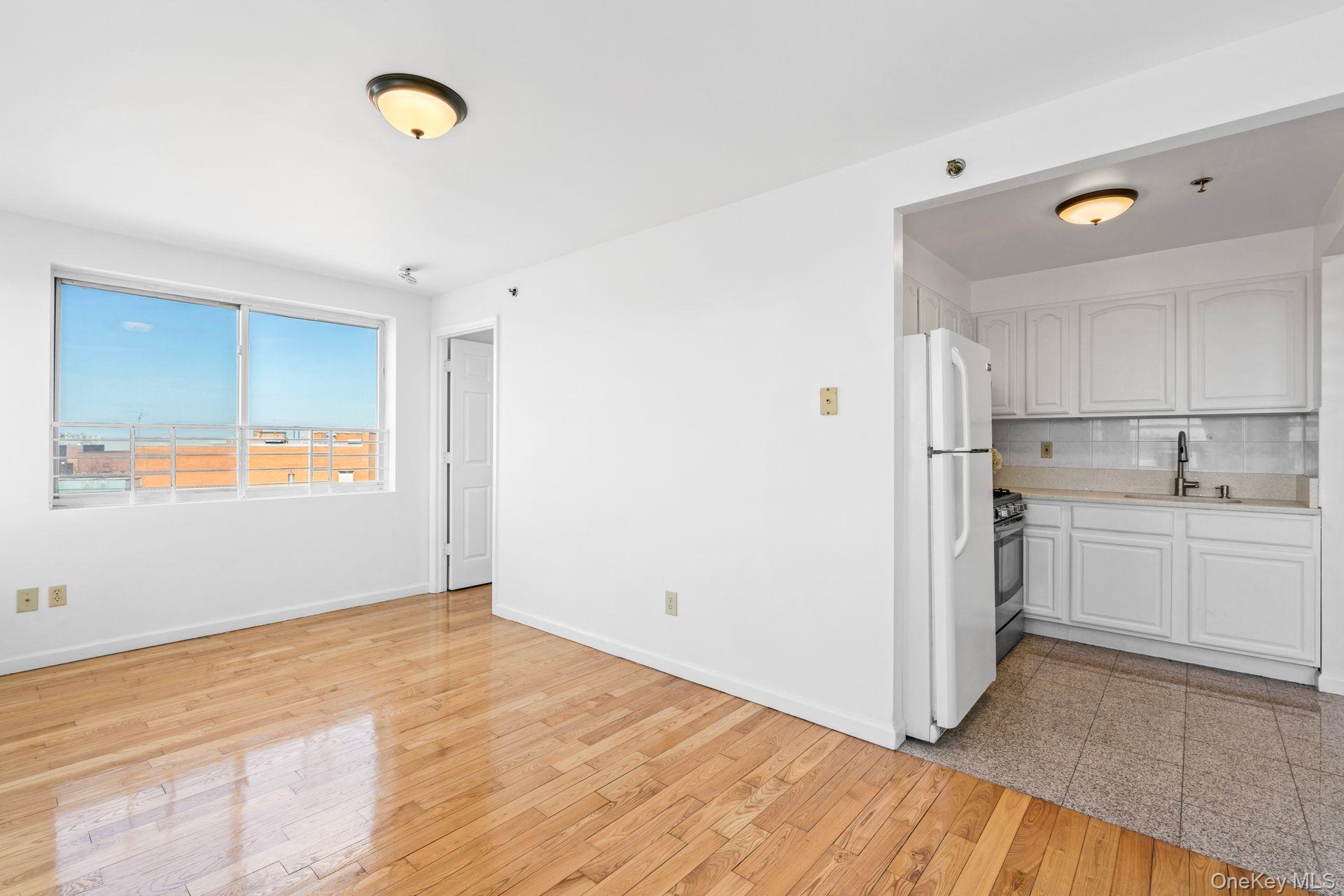 136-16 31st Road, Unit 8B Queens, NY 11354 - Photo 5 of 23 Kitchen with white cabinetry, sink, decorative backsplash, white refrigerator, and gas stove