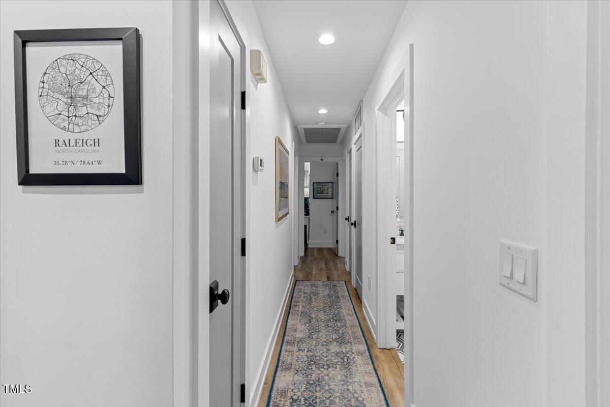 5700 Tully Court Raleigh, NC 27609 - Photo 16 of 26 a view of a hallway with paintings on the wall