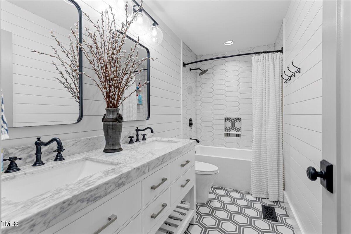 5700 Tully Court Raleigh, NC 27609 - Photo 17 of 26 a bathroom with a granite countertop sink mirror vanity and toilet