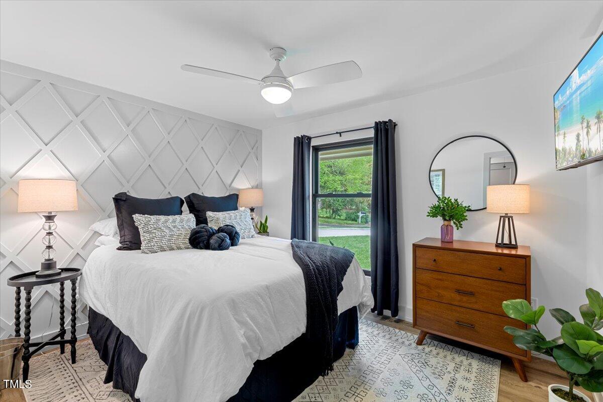 5700 Tully Court Raleigh, NC 27609 - Photo 18 of 26 a bed room with a bed potted plant and a window