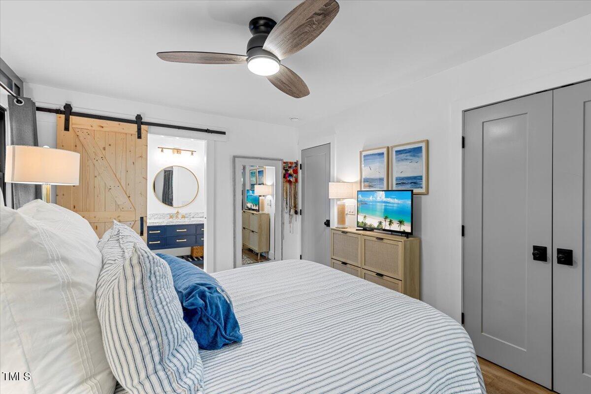 5700 Tully Court Raleigh, NC 27609 - Photo 20 of 26 a bed room with a bed mirror and a window