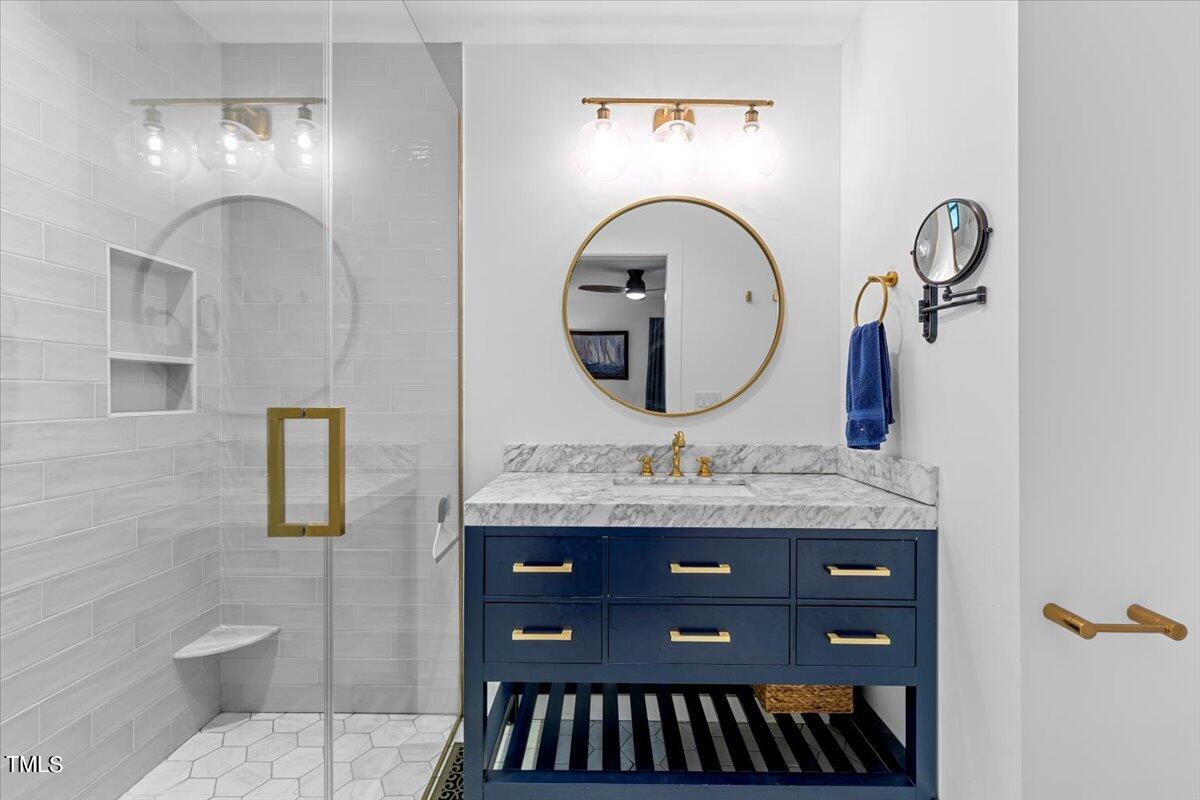 5700 Tully Court Raleigh, NC 27609 - Photo 21 of 26 a bathroom with a granite countertop toilet a sink and a mirror